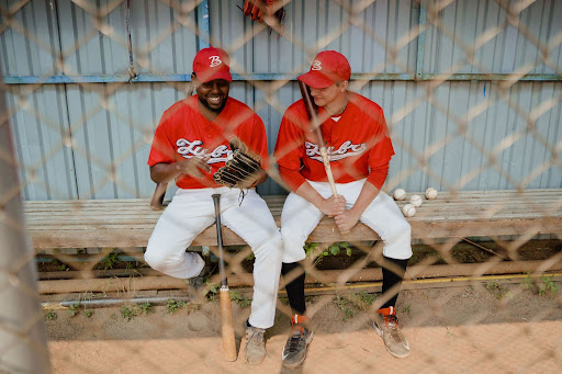 two-baseball-players-talking-in-dugout-red-uniforms